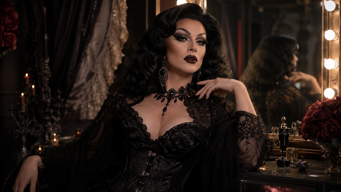 Drag queen con look dark glam, peluca voluminosa, maquillaje dramático, vestuario negro brillante y accesorios de impacto en camerino teatral.